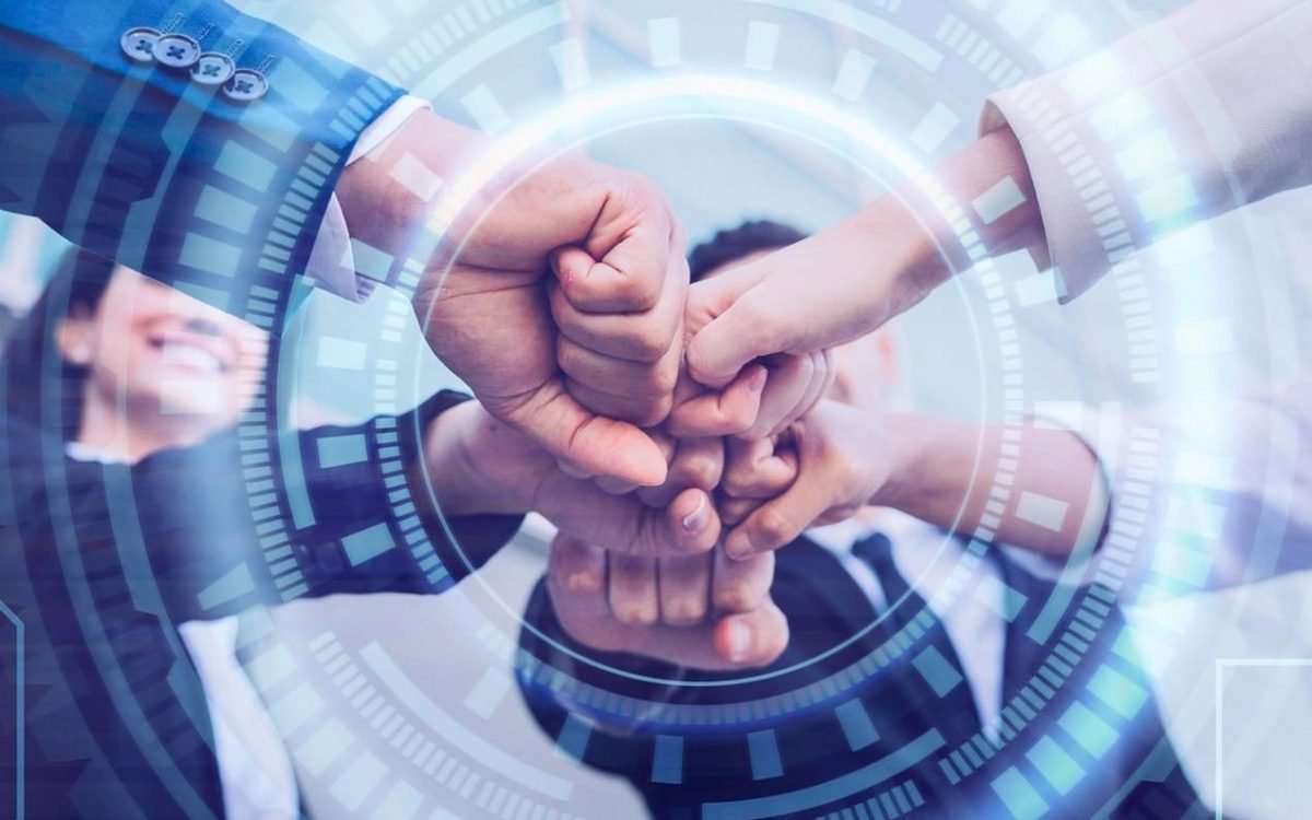 Team joining hands over a circuit-board graphic