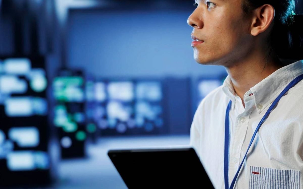 Security analyst holding a tablet in a monitoring centre